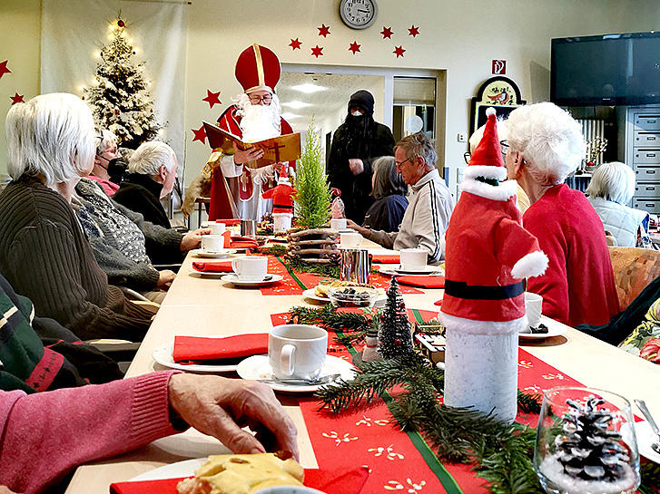 Nikolaus und Knecht Ruprecht verteilen Geschenke