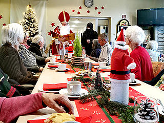 Nikolaus und Knecht Ruprecht verteilen Geschenke