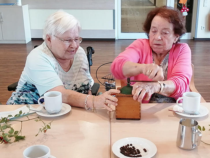 Bewohnerinnen mahlen Kaffeebohnen